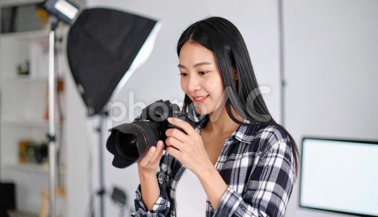 写真撮影を行う20代の女性カメラマン ミラーレス一眼レフカメラ,プロフェッショナル,スナップショットの写真素材