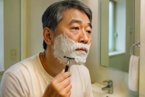 シェービングフォームをつけて髭を剃る男性 シェービングフォームをつけて髭を剃る男性の写真