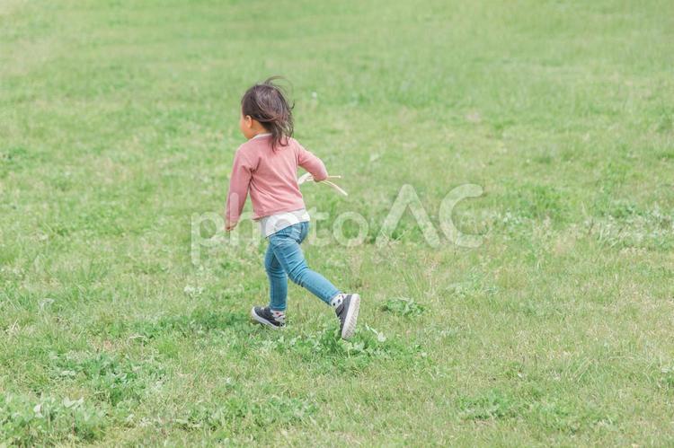 広い公園でおもちゃを持って走り回る子供 子供,女の子,子どもの写真素材
