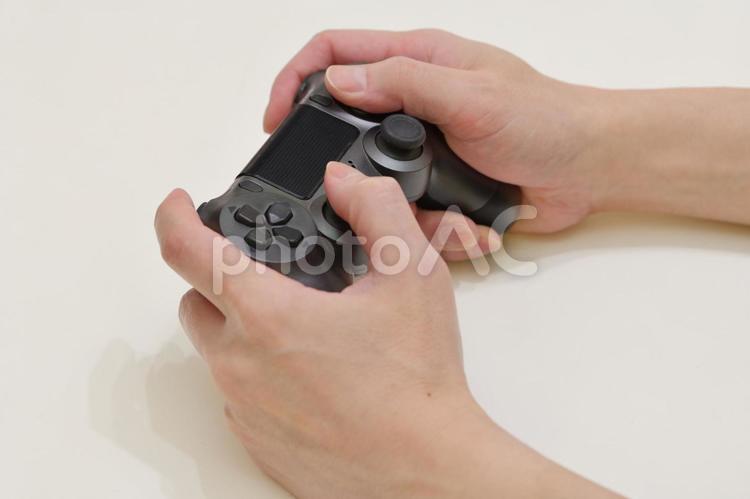 黒いコントローラーでゲームをしている手元 ゲーム,コントローラー,手元の写真素材