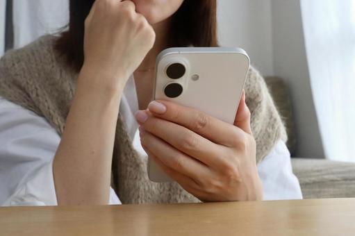 スマホを見ながら考える女性 スマホ,女性,ビジネスの写真素材