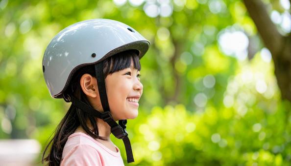 自転車用ヘルメットをかぶる女の子 自転車用ヘルメットをかぶる女の子の写真