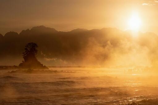 昇る朝日と毛嵐の雨晴海岸全景｜年賀状 日の出,毛嵐,波の写真素材