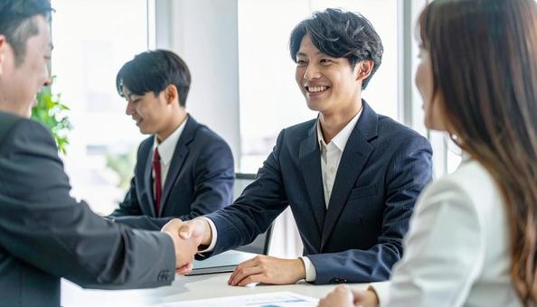 握手するビジネスパーソン 握手するビジネスパーソンの写真