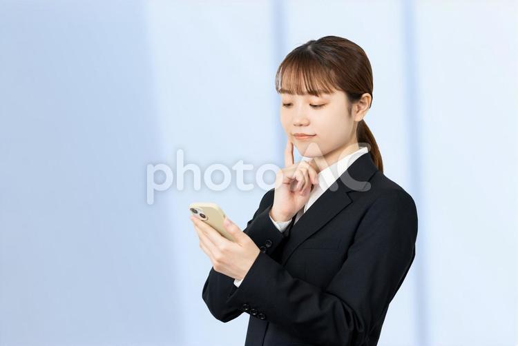 スマホを見て考えるビジネスウーマン 女性,スマホ,ビジネスの写真素材