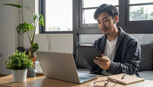 自宅のリビングで英会話の勉強をする男性 自宅のリビングで英会話の勉強をする男性の写真