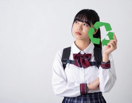 リサイクルマークを持つ女子高生のイメージ リサイクルマークを持つ女子高生のイメージの写真