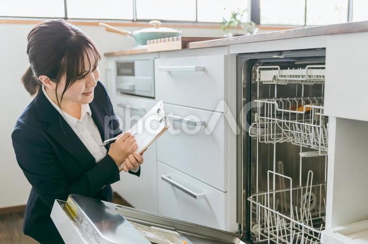 食洗機のチェックをするビジネスウーマン 食洗機,家電,食器洗いの写真素材