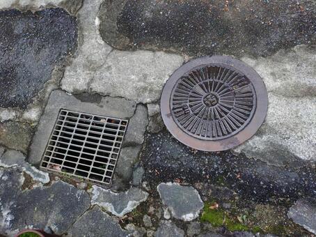 つぎはぎだらけの道路とマンホール マンホール,グレーチング,排水溝の写真素材