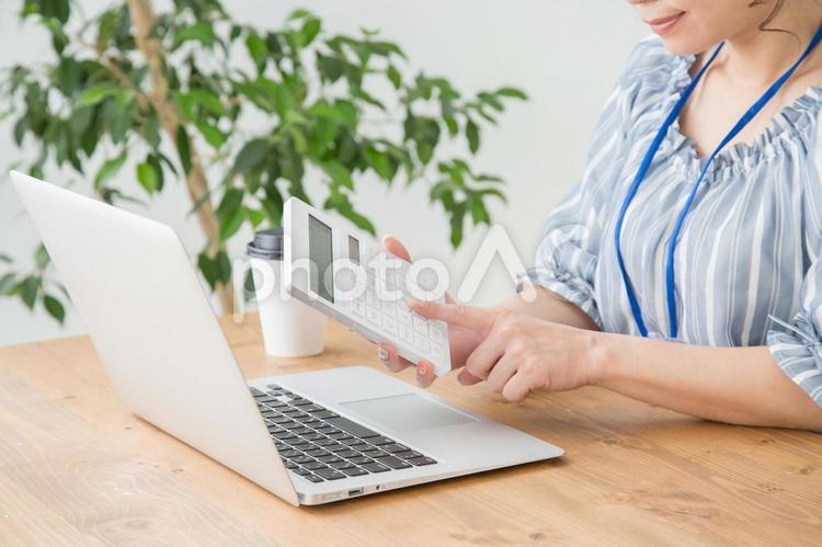 電卓を打つ女性 電卓,税金,補助金の写真素材