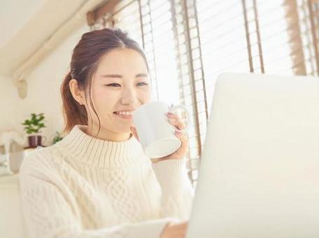 Asian female using a computer at home Asian female using a computer at home