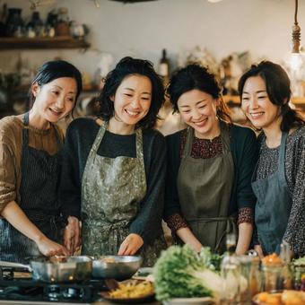 4人の女性たちが一緒に料理するキッチン 4人の女性たちが一緒に料理するキッチンの写真