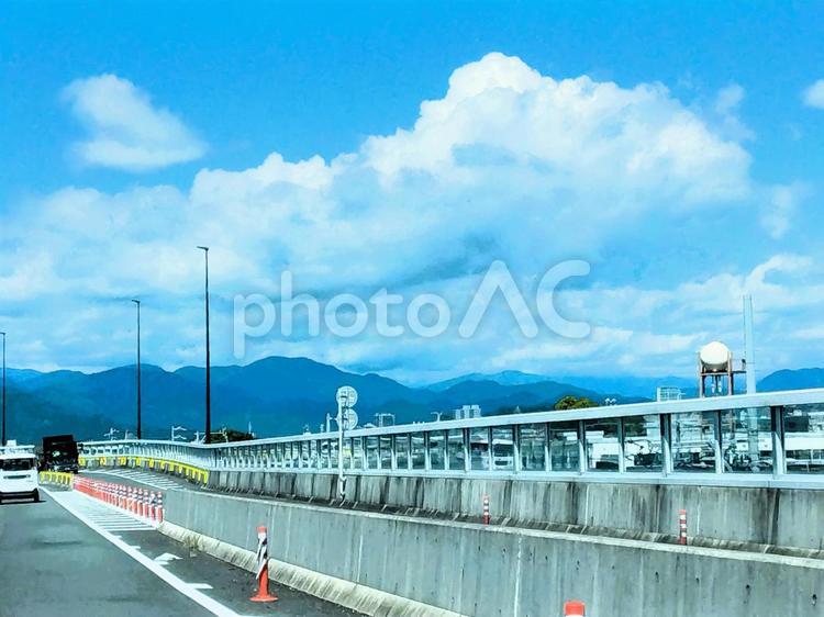 もくもくの雲と山　高架道路の風景 雲,空,青空の写真素材