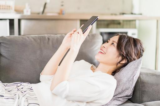 Young woman using a smartphone in her room, JPG