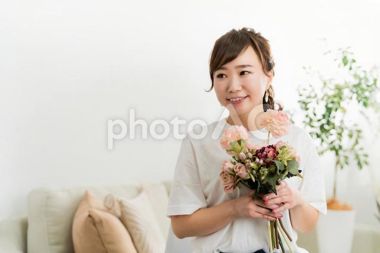 家のソファで花束を持つ日本人女性 母の日,花束,花の写真素材