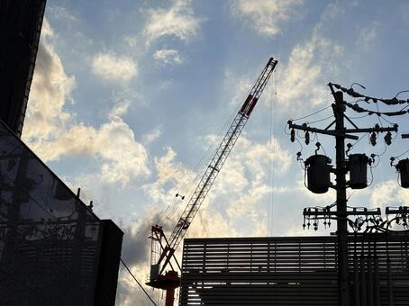 夕空に伸びるクレーンと電柱のシルエット クレーン,夕空,夕景の写真素材