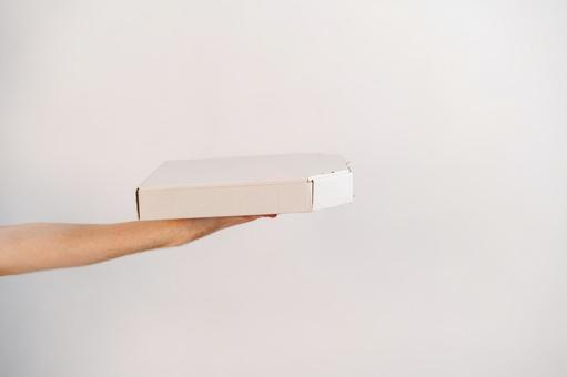 ピザ箱を差し出している手 配達,フードデリバリー,テイクアウトの写真素材