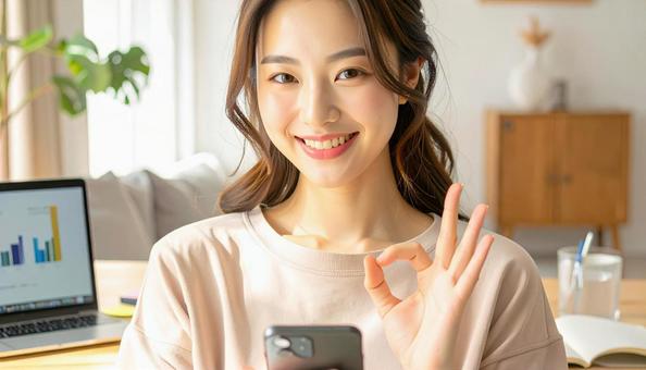 家計がうまくいきスマホ片手に微笑む女性 家計がうまくいきスマホ片手に微笑む女性の写真