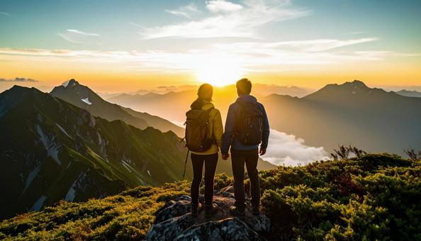 山から朝日を眺める日本人カップル 山から朝日を眺める日本人カップルの写真
