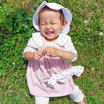 芝生に寝転がる笑顔の赤ちゃん 芝生に寝転がる笑顔の赤ちゃん 子供,子ども,赤ちゃんの写真素材