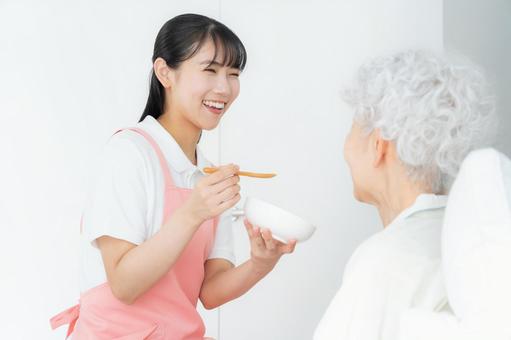 寝ているシニア女性を介護をする介護士 寝ているシニア女性を介護をする介護士 食事,介護,介護士の写真素材