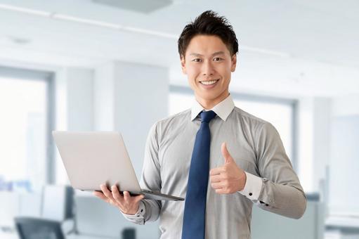 パソコンを持っていいねのポーズをする男性 パソコンを持っていいねのポーズをする男性 男性,パソコン,ビジネスの写真素材