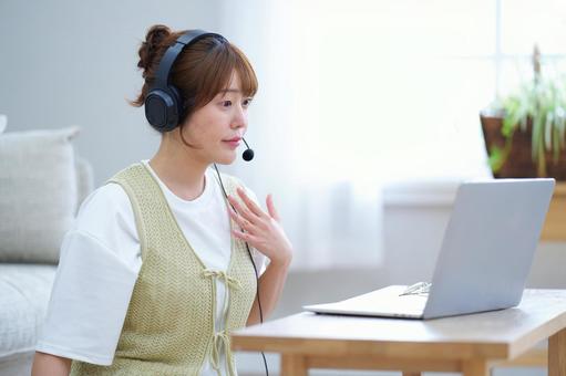 パソコンを見るヘッドセットの女性 女性,ノートパソコン,見るの写真素材