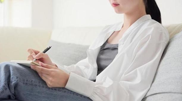 自宅でアイデアをメモするアジア人女性 自宅でアイデアをメモするアジア人女性 アイデア,メモ,考えるの写真素材