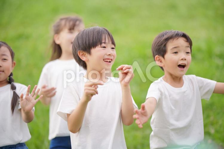 笑顔で遠くを見ている小学生4人の上半身 男の子,女の子,遠くの写真素材