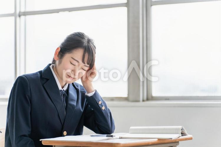 学校の教室で悩む・困る女子高校生（頭痛） 頭痛,高校生,体調不良の写真素材