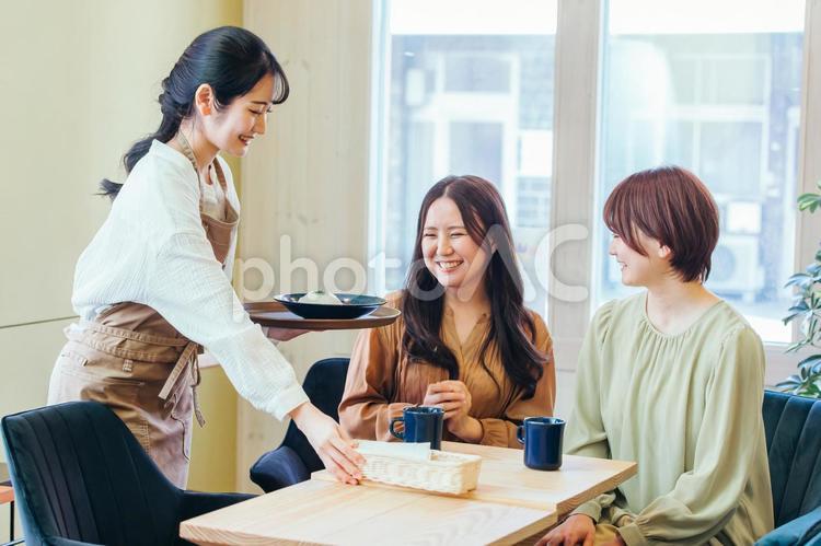 ランチを食べる客とカフェスタッフ ランチ,レストラン,カフェの写真素材
