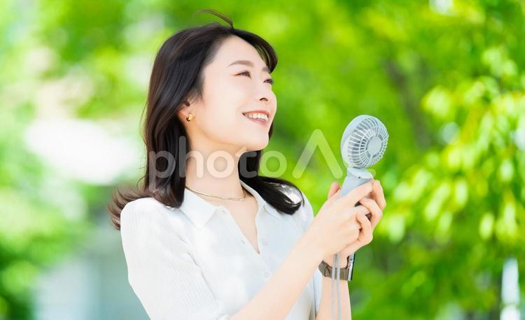 ハンディファンで涼む女性・熱中症対策 女性,夏,扇風機の写真素材