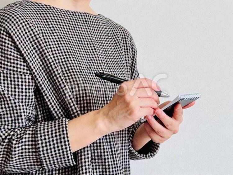 メモを取る女性（チェック柄の服） メモる,メモ帳,女性の写真素材
