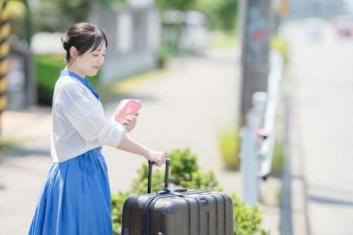 パスポートとスーツケースを持つ女性 パスポートとスーツケースを持つ女性 女性,スーツケース,キャリーケースの写真素材