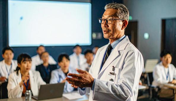 男性医師が壇上で発表、説明をする勉強会 男性医師が壇上で発表、説明をする勉強会の写真