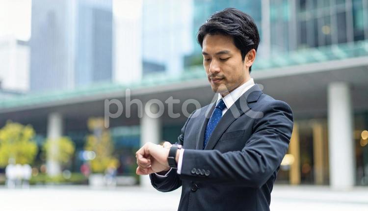 腕時計を見るビジネスマン　街中 ビジネスマン,男性,腕時計の写真素材
