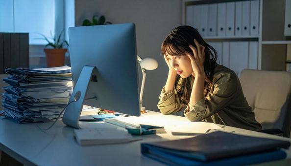 深夜残業する女性社員 深夜残業する女性社員の写真