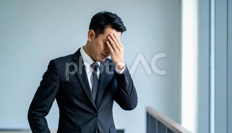 ストレスで顔をおおう日本人ビジネスマン ビジネスマン,サラリーマン,ストレスの写真素材