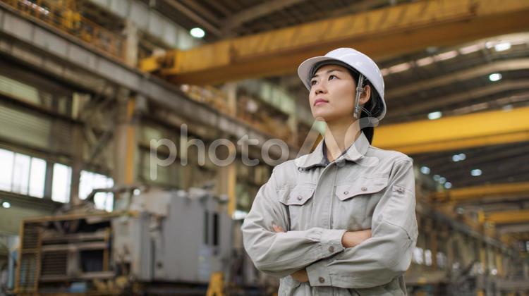 工場を見つめる女性作業員 女性,作業員,工場の写真素材