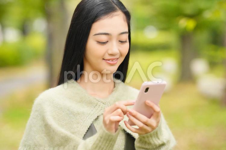 公園でスマホを使う女性 女性,日本人,１人の写真素材