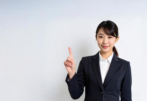 人差し指を立てるスーツの女性 人差し指を立てるスーツの女性の写真