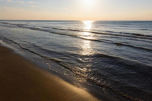 夕日に照らされる美しい砂浜と海 夕日に照らされる美しい砂浜と海 石川県,なぎさドライブウェイ,海の写真素材