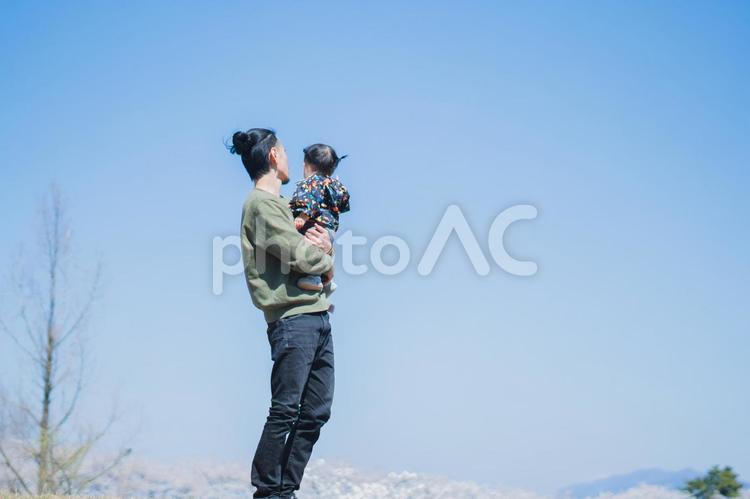 晴天の下、抱っこされる娘 親子,家族,子供の写真素材