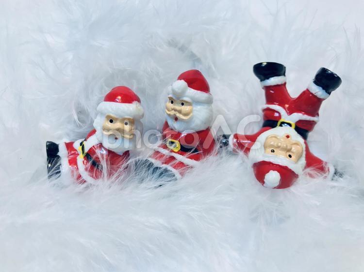 サンタクロースの人形たちと羽毛の背景、クリスマスイメージ クリスマス,サンタクロース,サンタさんの写真素材