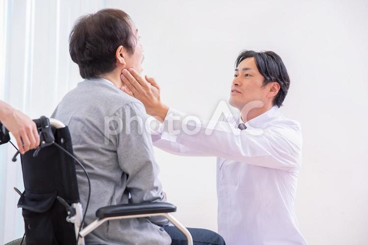 口を見る医師と車椅子に乗った患者（歯医者） 歯医者,入れ歯,歯周病の写真素材