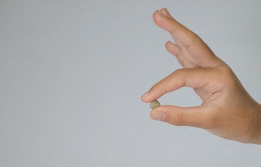 小さなサプリメントを摘む手 サプリメント,手,健康の写真素材