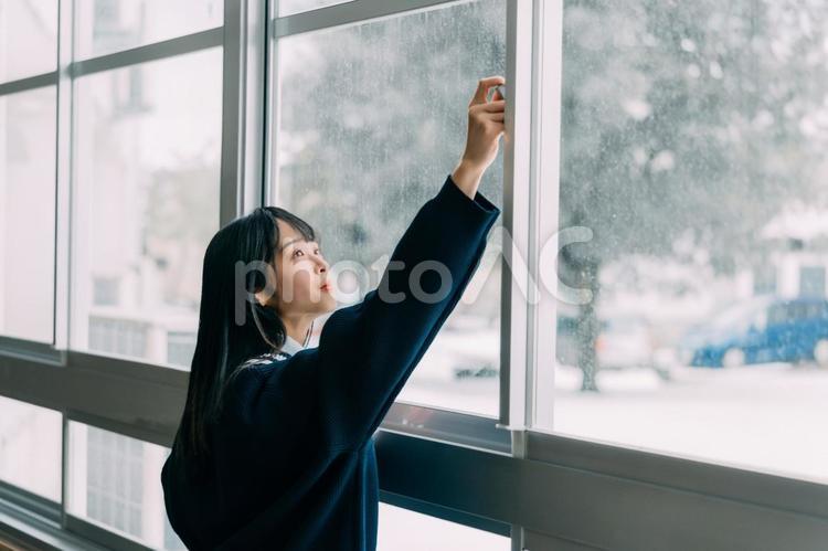 教室の窓を開けようとする女子高校生 女子高校生,高校生,学生の写真素材