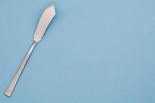 水色の背景に置かれたバターナイフ バターナイフ,カトラリー,食器の写真素材