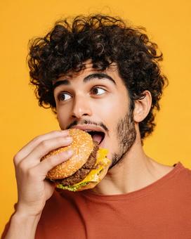 食欲をそそるハンバーガーと若者の表情 食欲をそそるハンバーガーと若者の表情の写真