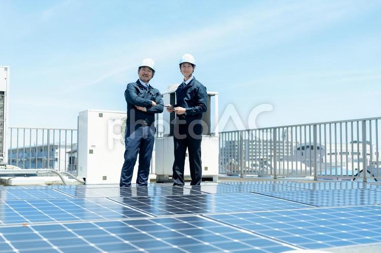 現場で打ち合わせする作業服のビジネスマン 現場で打ち合わせする作業服のビジネスマン 作業服,打ち合わせ,ヘルメットの写真素材